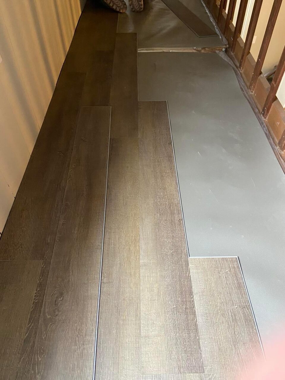 Vinyl plank floor installation along a hallway