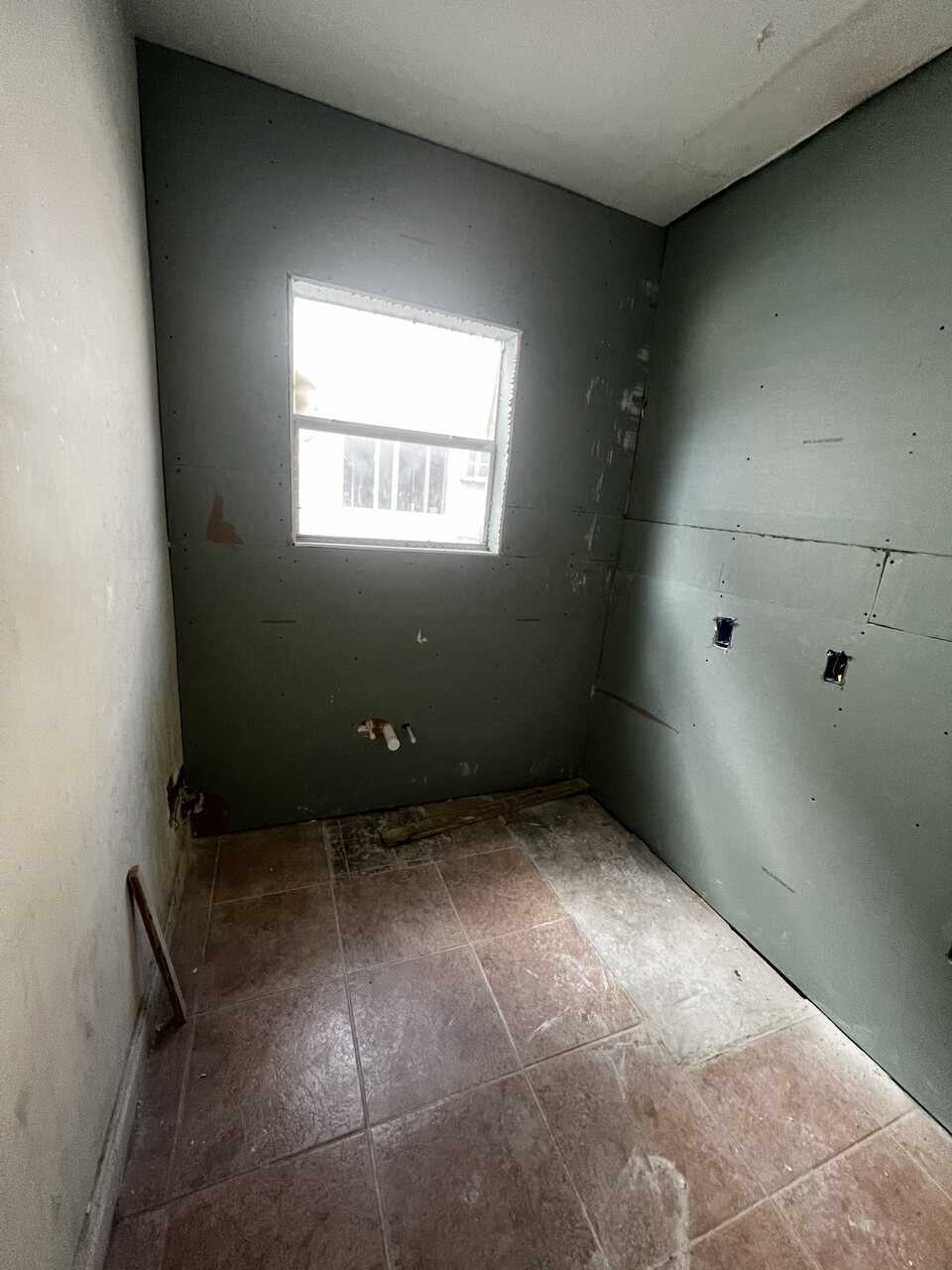 Bathroom plumbing stub-outs through moisture-resistant drywall