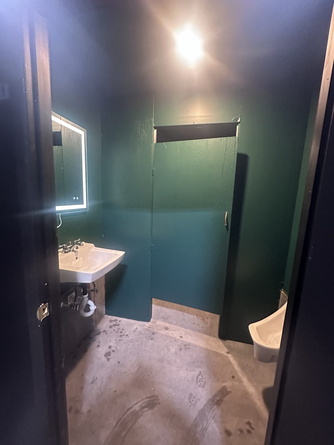 Commercial restroom with sink and urinal plumbing fixtures
