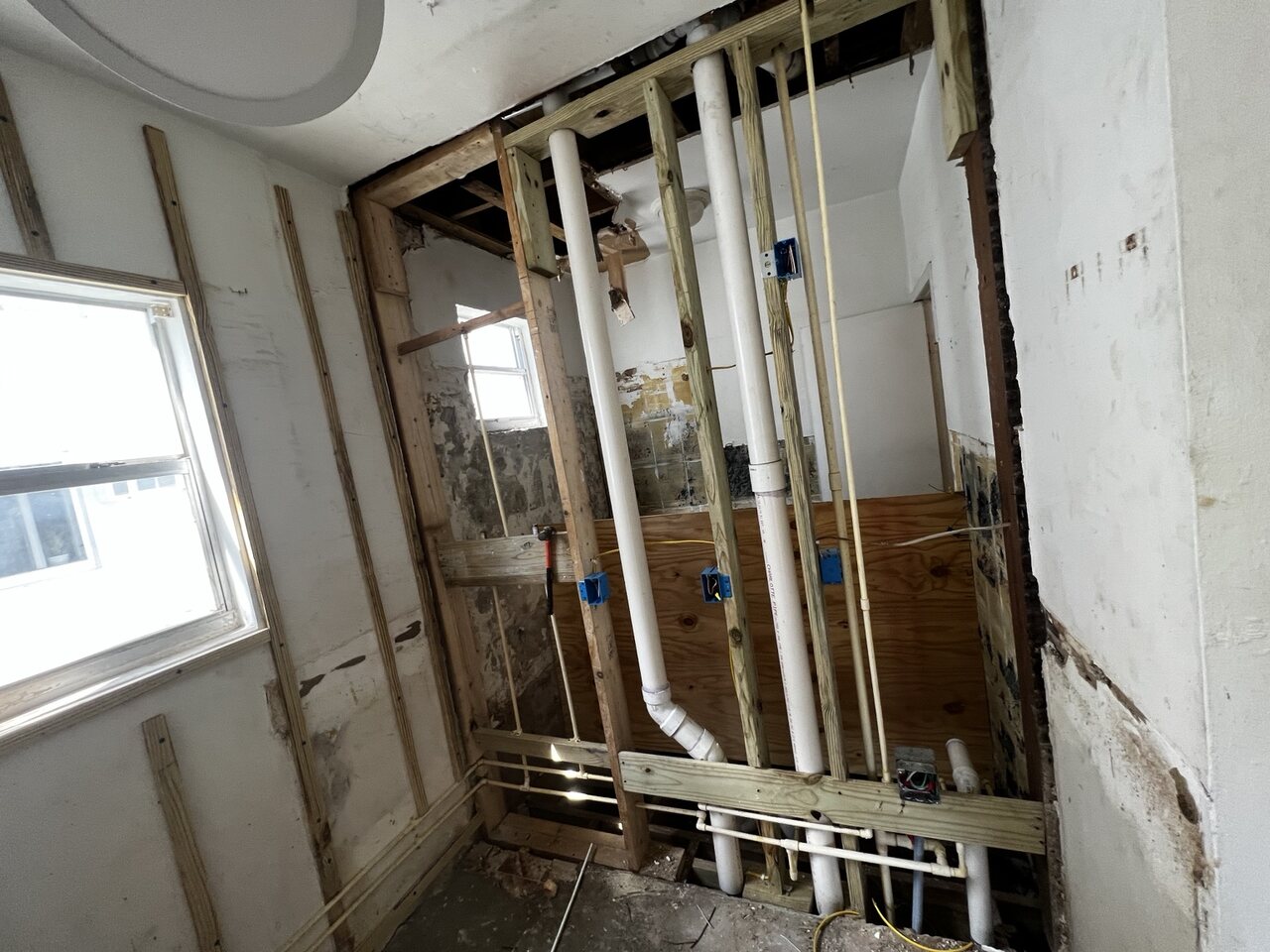 Plumbing drain and supply lines installed inside a bathroom wall