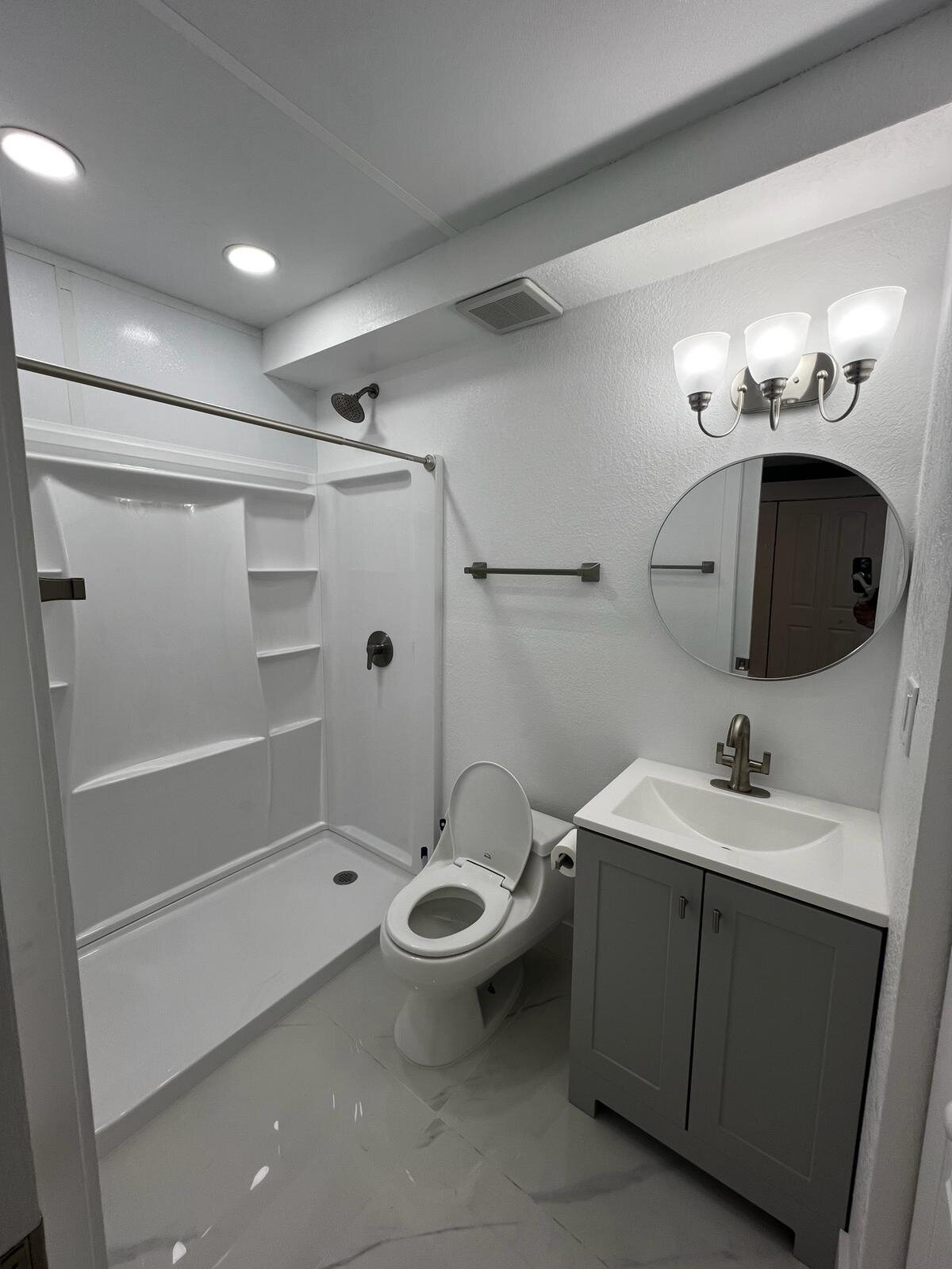 Finished bathroom with toilet, shower and vanity